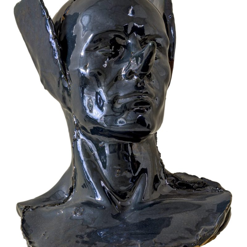 Busto in ceramica nero raffigurante il volto silenzioso di un uomo calvo a cui vengono tappate le orecchie